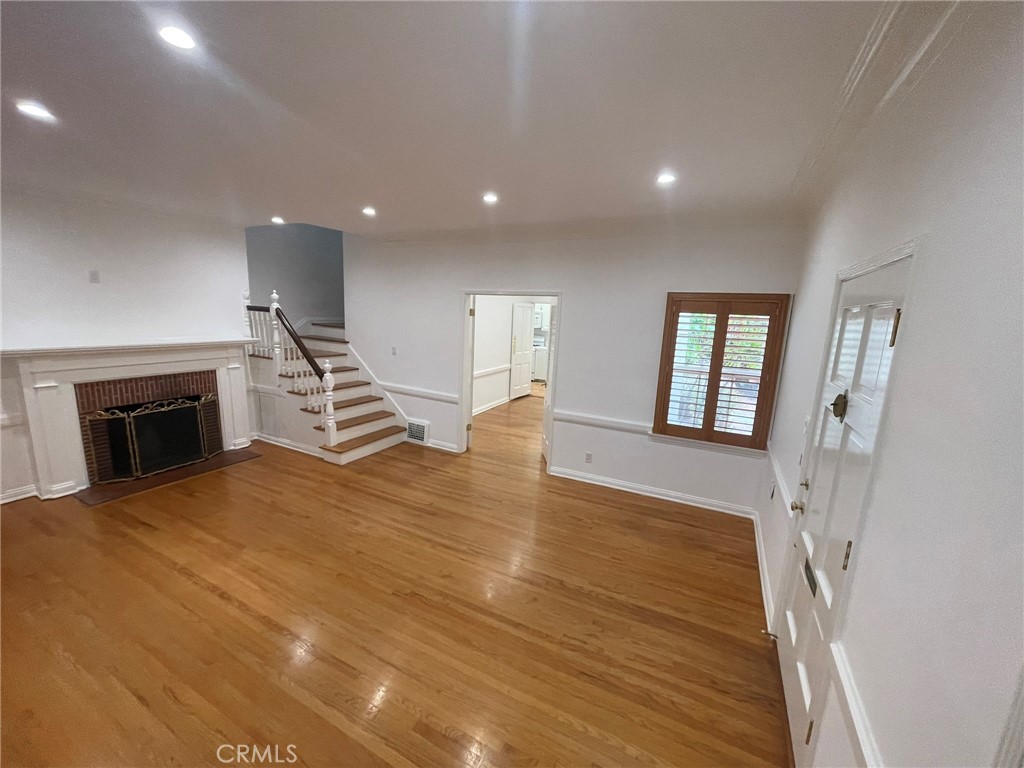 135 Canon Drive Beverly Hills, CA 90212 - Photo 13 of 42 a view of empty room with wooden floor and fireplace