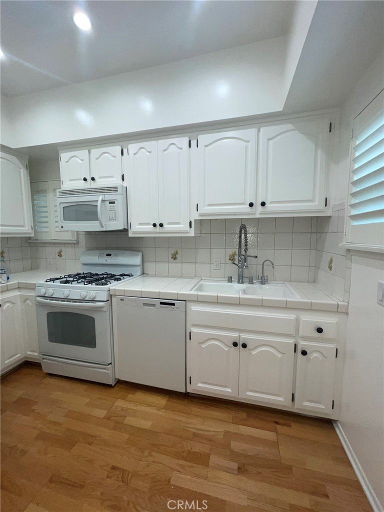 135 Canon Drive Beverly Hills, CA 90212 - Photo 15 of 42 a kitchen with granite countertop white cabinets and white stainless steel appliances