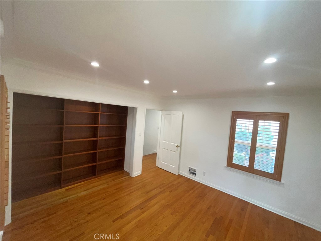 135 Canon Drive Beverly Hills, CA 90212 - Photo 21 of 42 a view of an empty room with a window and wooden floor