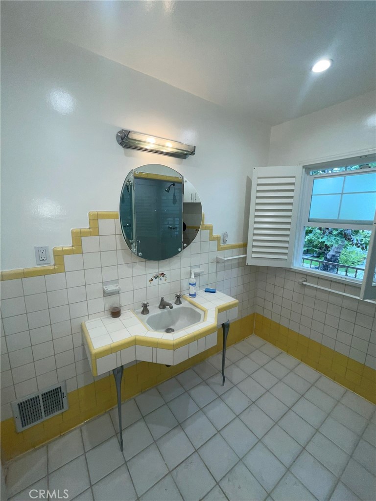 135 Canon Drive Beverly Hills, CA 90212 - Photo 22 of 42 a bathroom with a sink and a mirror