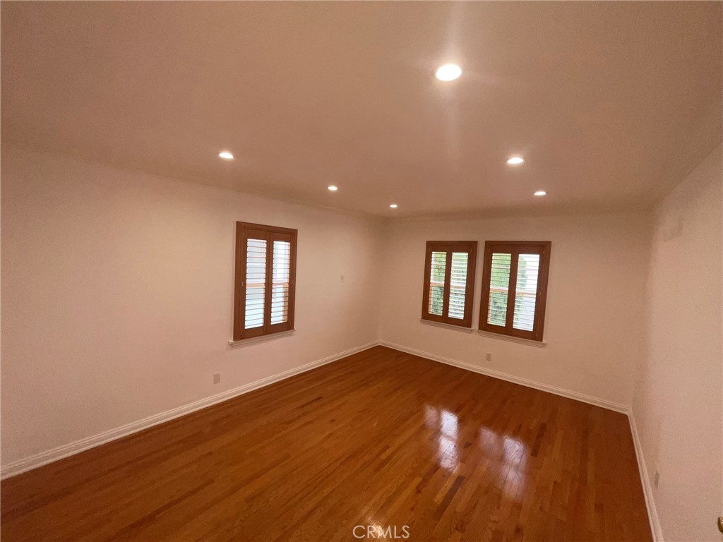 135 Canon Drive Beverly Hills, CA 90212 - Photo 27 of 42 an empty room with wooden floor and windows
