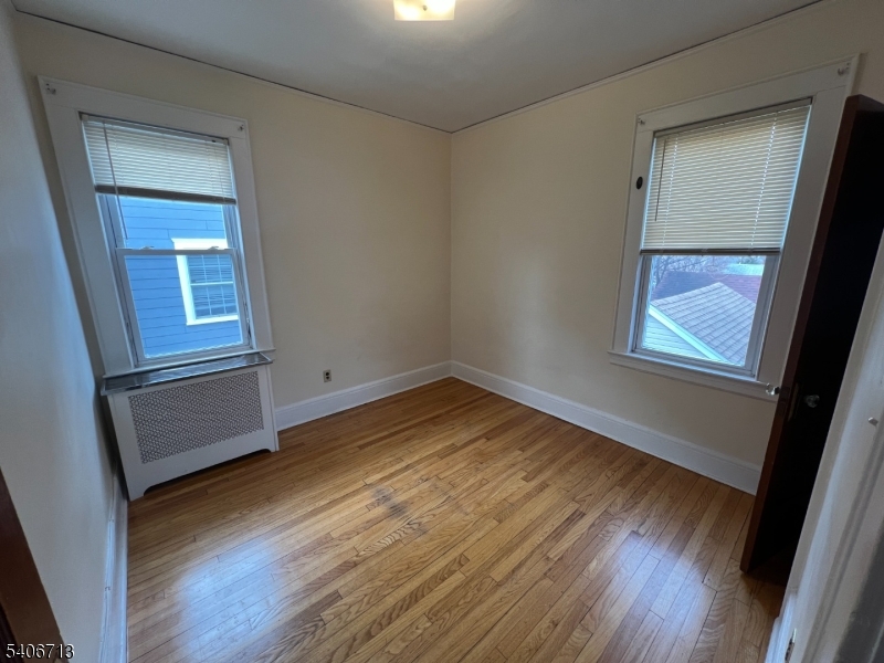 1044 Cross Avenue Elizabeth, NJ 07208 - Photo 7 of 9 an empty room with wooden floor and windows