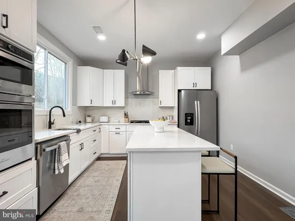 a kitchen with kitchen island a sink appliances and cabinets