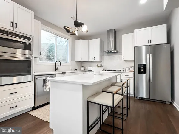 a kitchen with kitchen island white cabinets and stainless steel appliances
