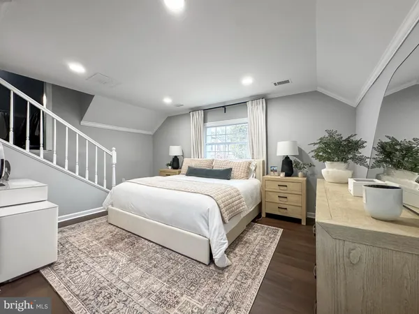 a bedroom with a large bed and a potted plant