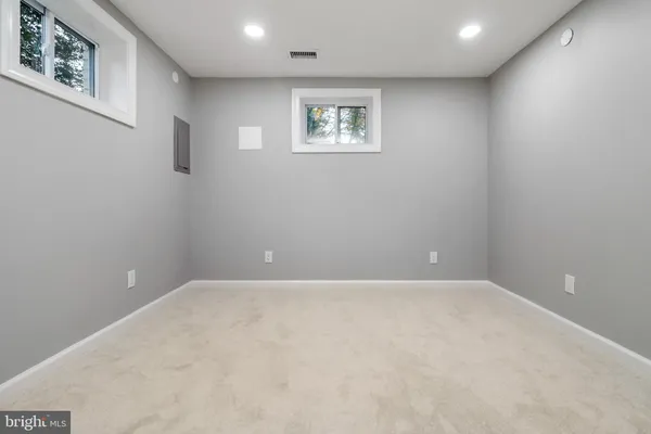a view of an empty room with wall painting and a lamp