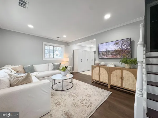 a living room with furniture a flat screen tv and a window