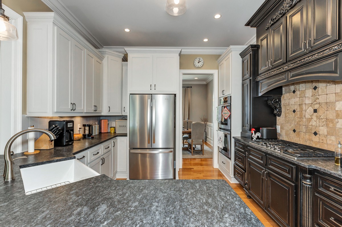 983 Veto Road Prospect, TN 38477 - Photo 9 of 43 a kitchen with granite countertop a refrigerator a sink and wooden cabinets