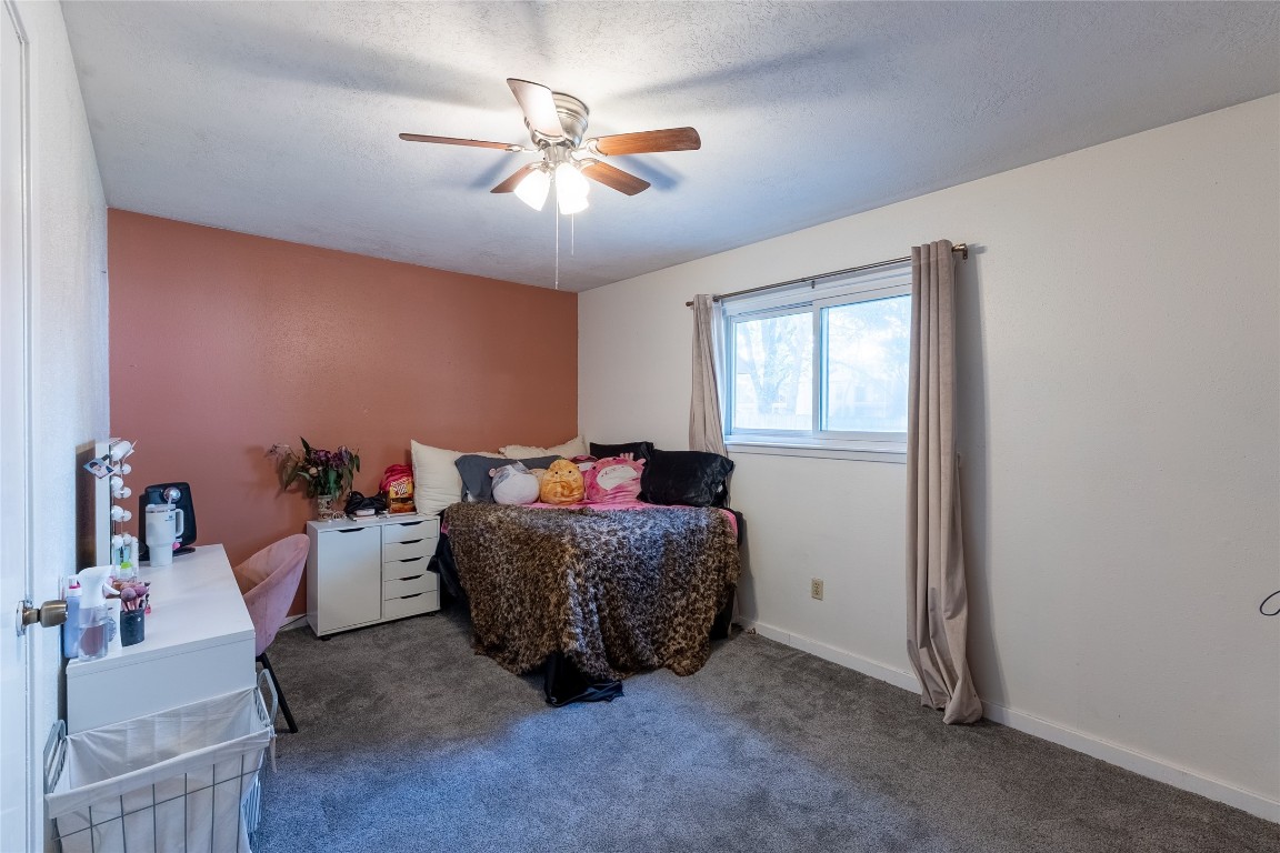 5818 Yorkgate Drive Spring, TX 77373 - Photo 14 of 19 Spacious bedroom with a warm accent wall, large window, and plush carpet — perfect as a relaxing retreat.