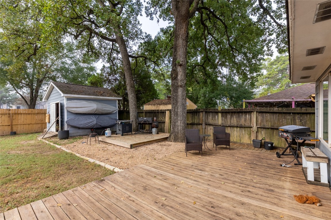 5818 Yorkgate Drive Spring, TX 77373 - Photo 18 of 19 Spacious backyard featuring a wood deck, grilling area, and a storage shed—perfect for relaxing or entertaining.
