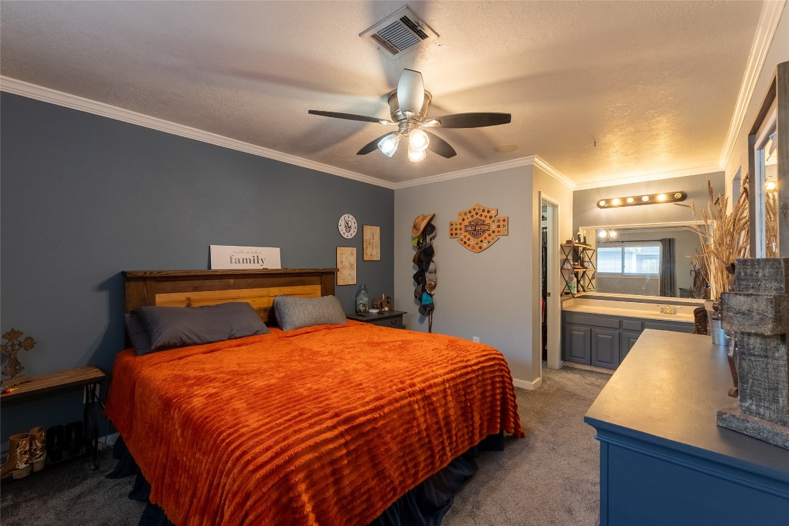 5818 Yorkgate Drive Spring, TX 77373 - Photo 9 of 19 Inviting primary suite with custom accent wall, crown molding, and direct access to a private vanity and ensuite bath.