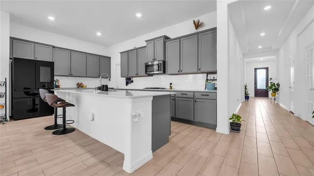 a kitchen with a sink cabinets and wooden floor