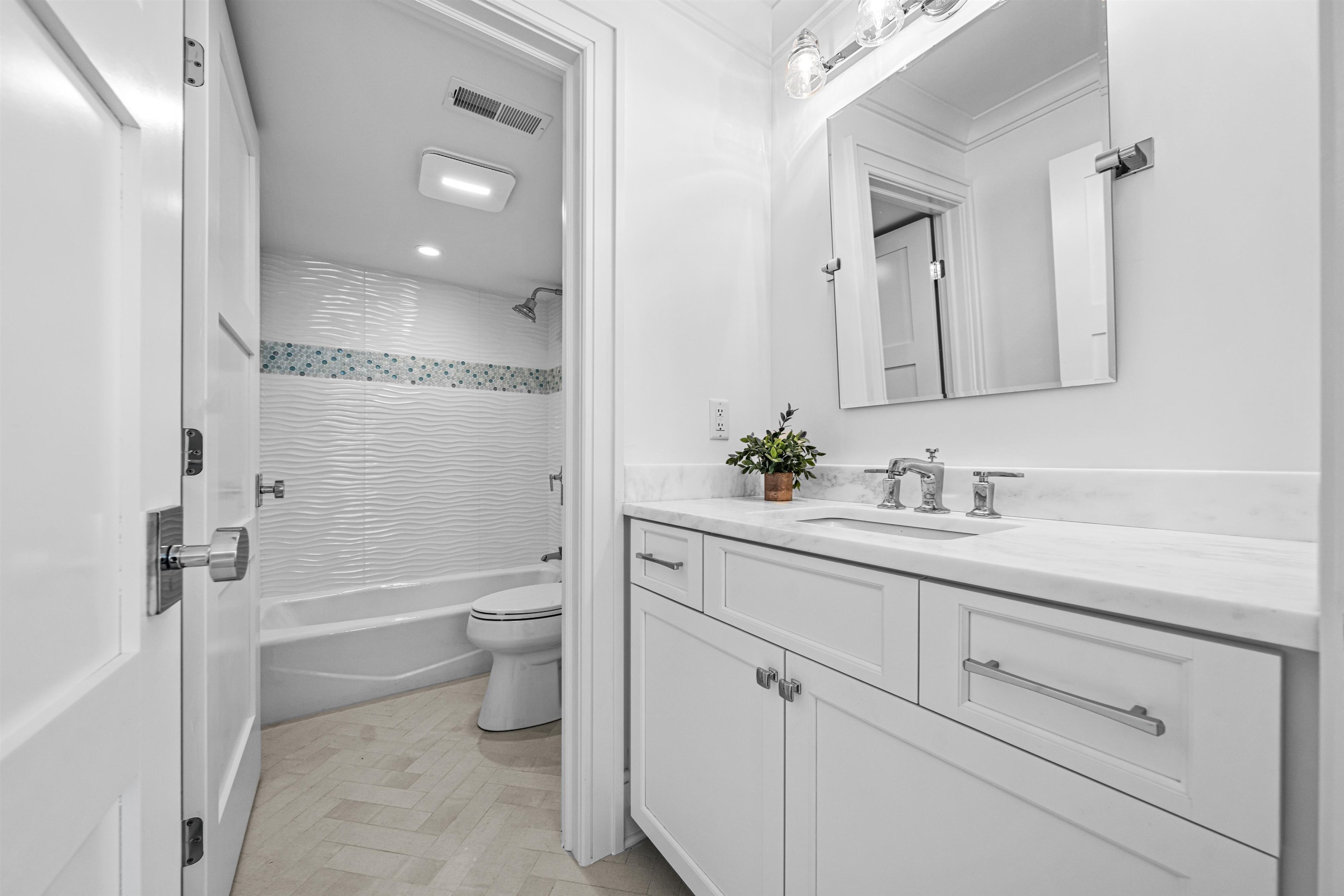 2158 Ocean Drive, Unit 2158 Avalon, NJ 08202 - Photo 12 of 50 a bathroom with a granite countertop sink a toilet and a bathtub