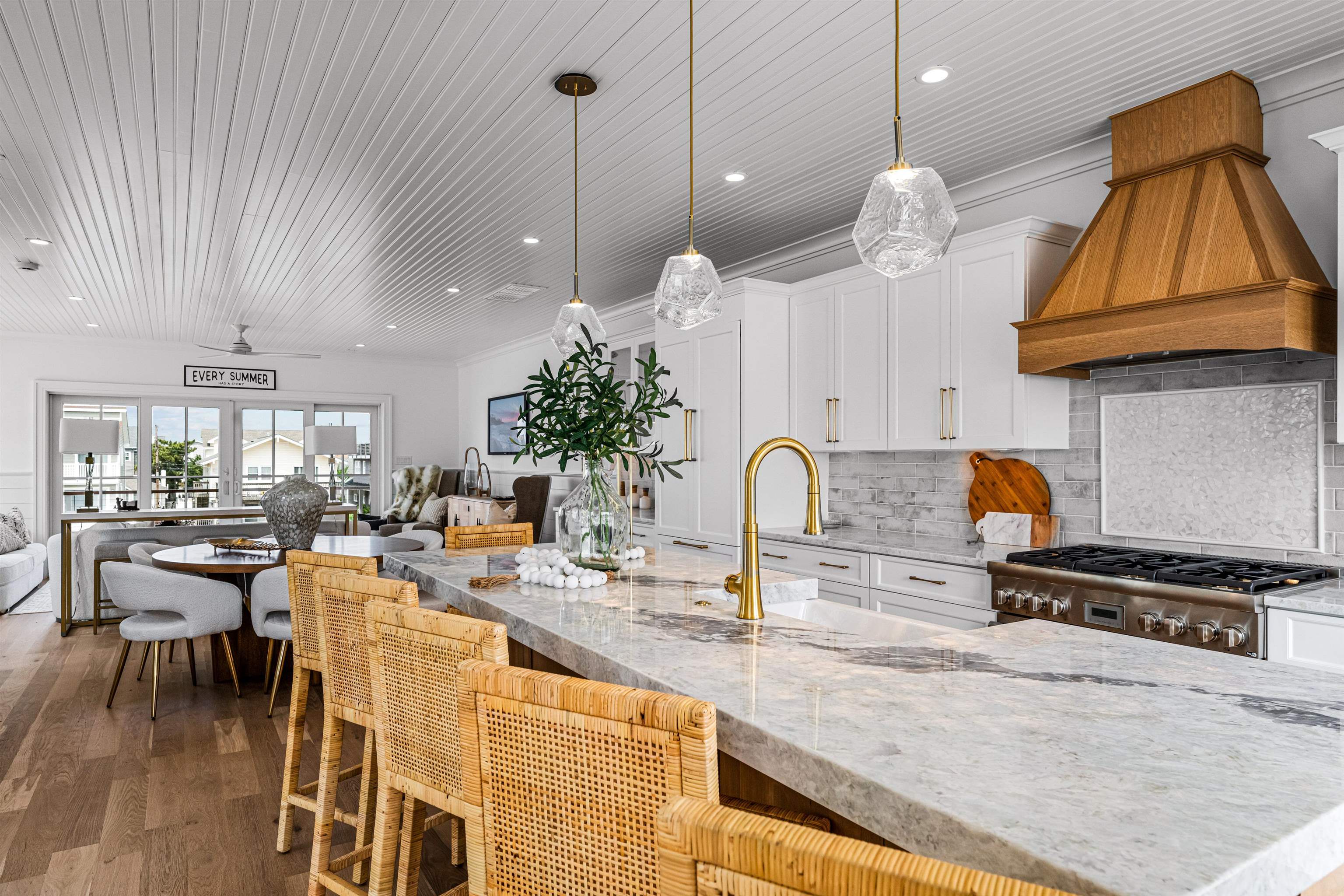 2158 Ocean Drive, Unit 2158 Avalon, NJ 08202 - Photo 25 of 50 a kitchen with stainless steel appliances kitchen island granite countertop a stove a sink a dining table and chairs with wooden floor