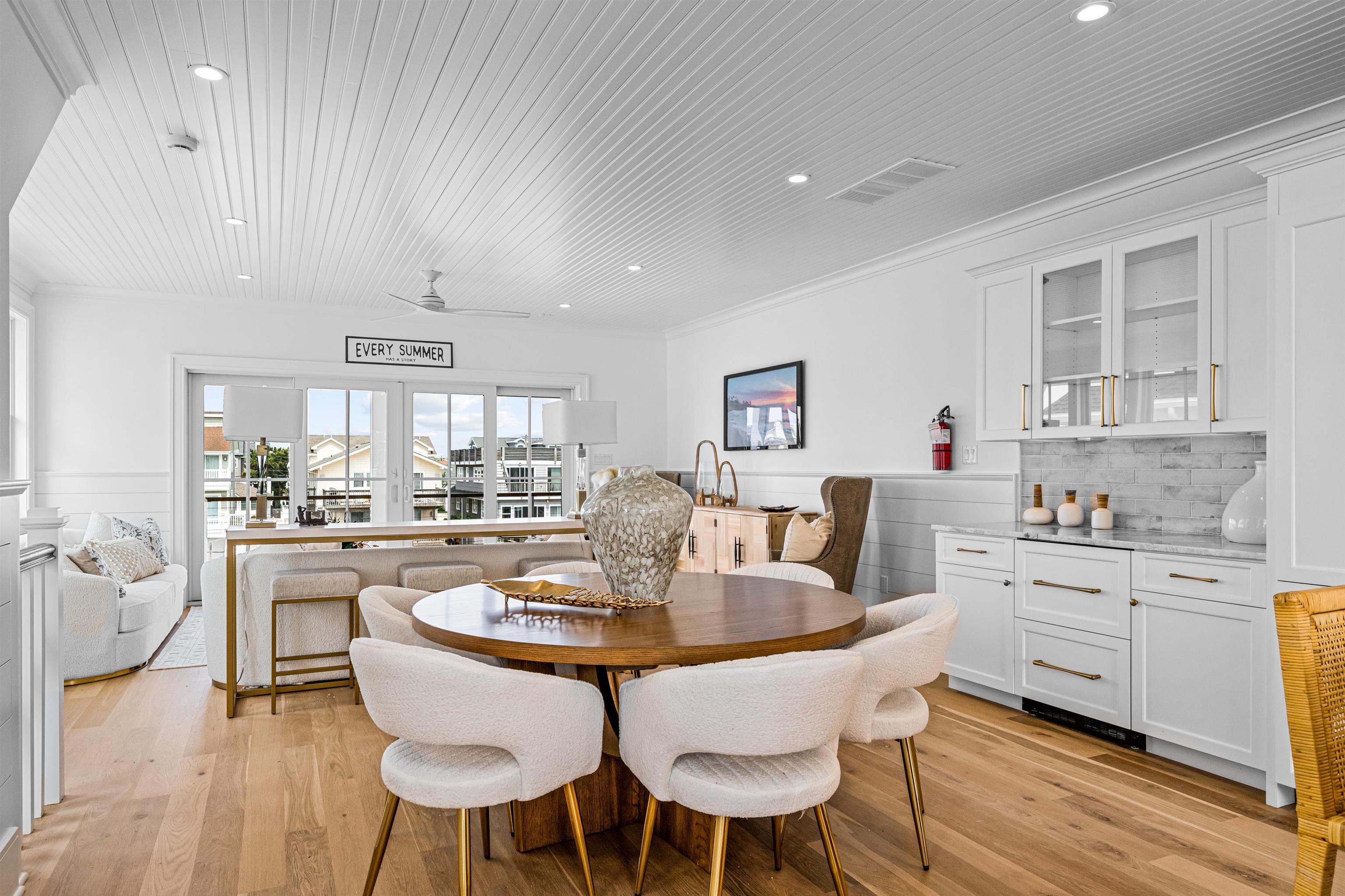 2158 Ocean Drive, Unit 2158 Avalon, NJ 08202 - Photo 28 of 50 a dining room with kitchen island furniture a chandelier stainless steel appliances and wooden floor