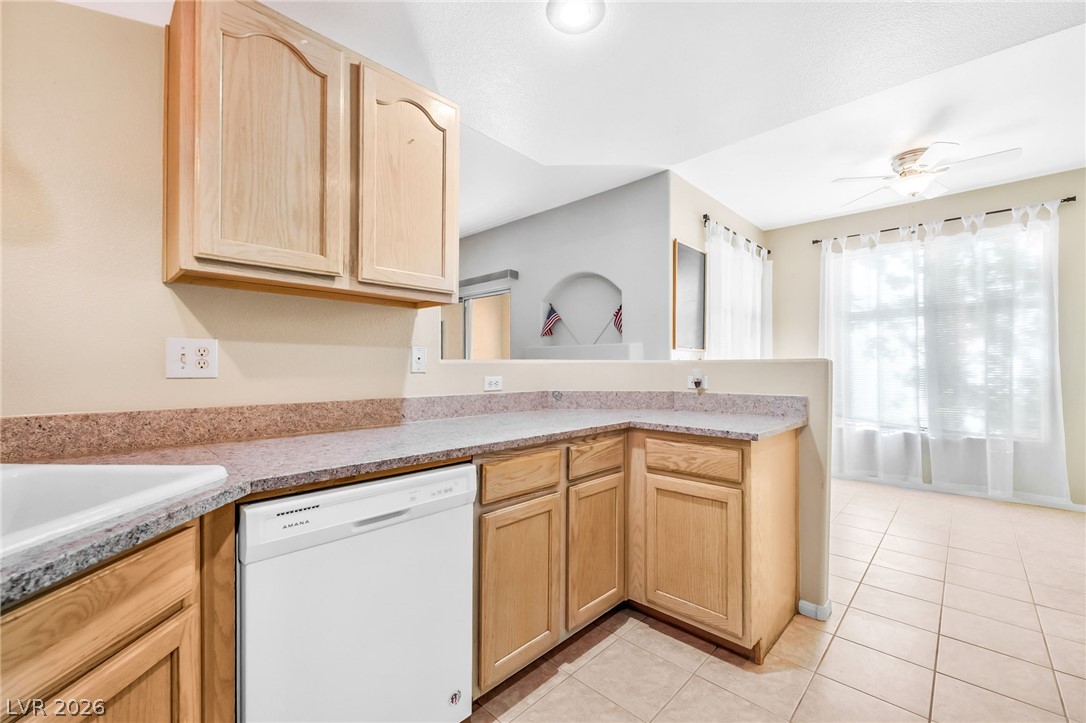 2050 West Warm Springs Road, Unit 2411 Henderson, NV 89014 - Photo 13 of 37 A well-appointed kitchen features ample counter space, rich wooden cabinetry, and tile flooring.