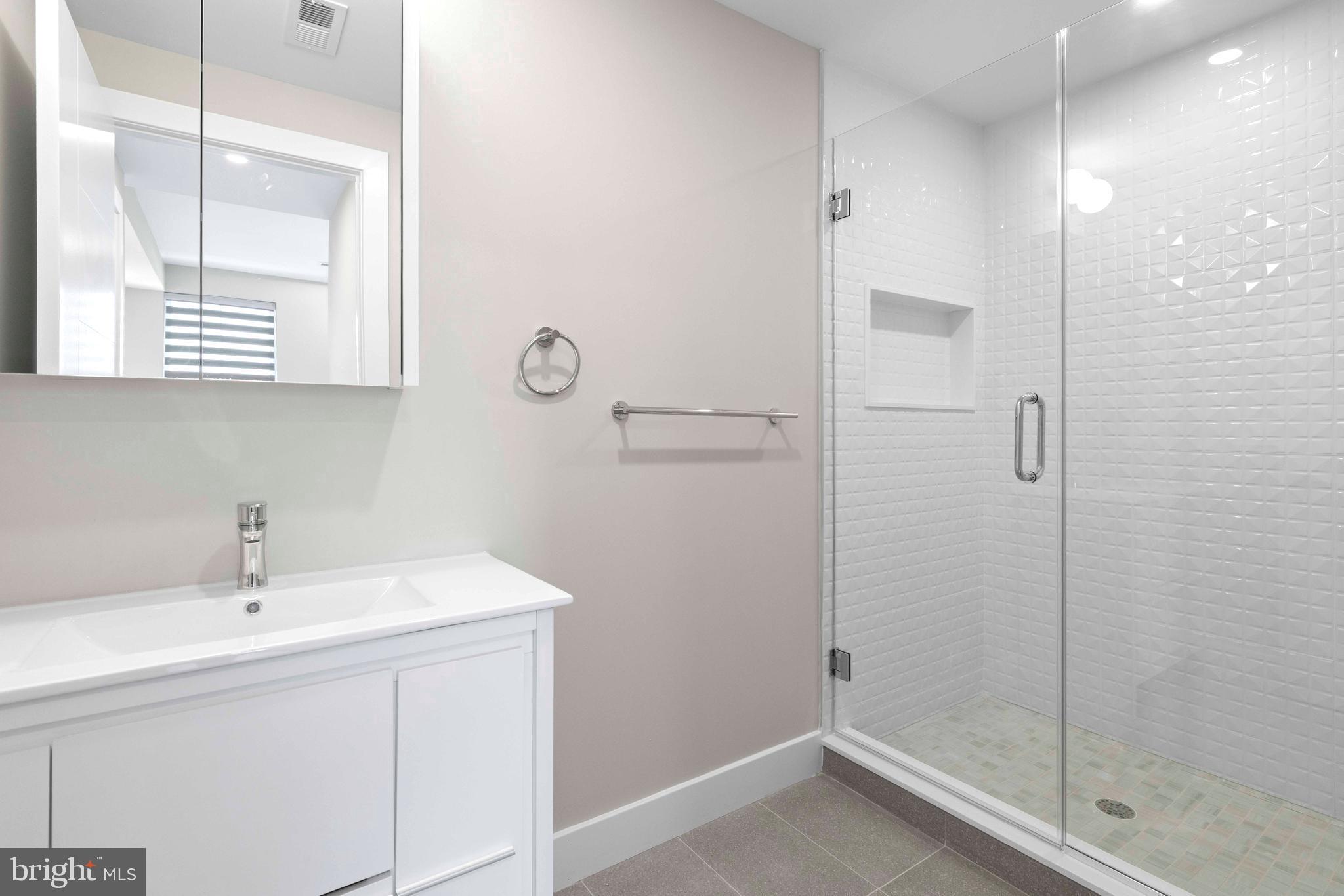 4720 Richmond Street, Unit 4 Philadelphia, PA 19137 - Photo 12 of 26 a bathroom with a sink a mirror and shower