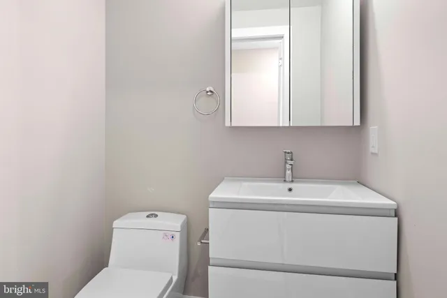 a bathroom with a toilet sink and mirror