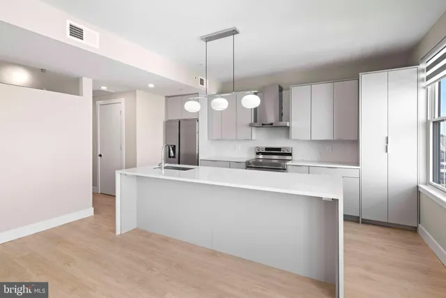 a kitchen with stainless steel appliances a sink stove and refrigerator