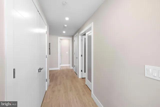 a view of a hallway with wooden floor