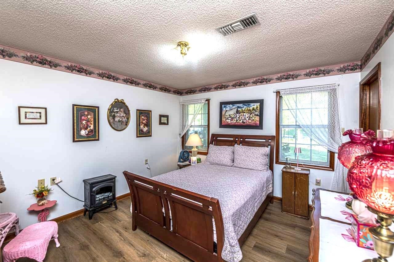 937 Kelleys Chapel Road Burlison, TN 38015 - Photo 18 of 40 Bedroom featuring a textured ceiling and dark wood-style flooring