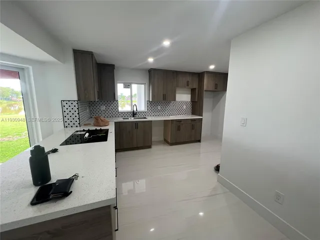 a kitchen with stainless steel appliances a sink stove and cabinets