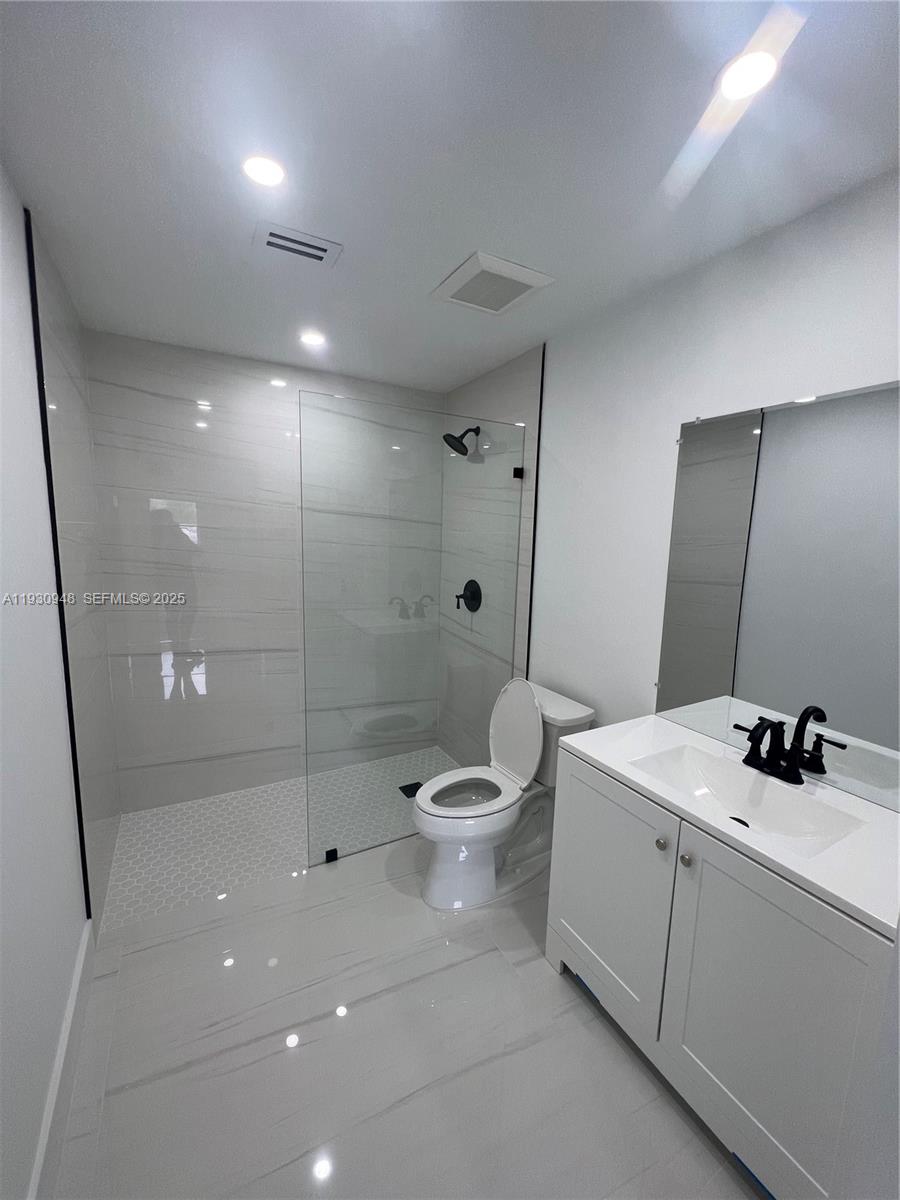 14830 Harding Lane Homestead, FL 33033 - Photo 6 of 12 a bathroom with a sink a toilet a mirror and shower