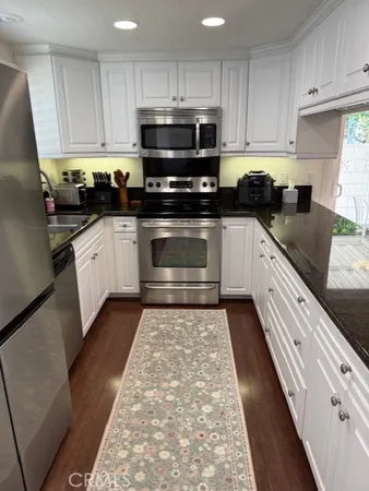 a kitchen with stainless steel appliances granite countertop a stove a sink and a microwave