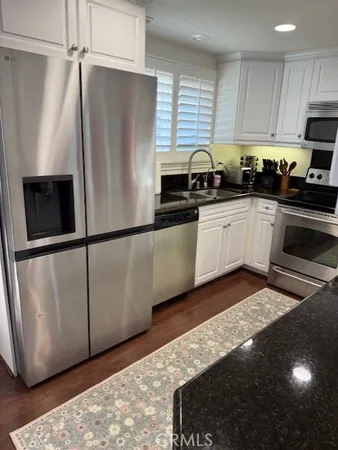 a kitchen with stainless steel appliances granite countertop a refrigerator a stove a sink and a microwave