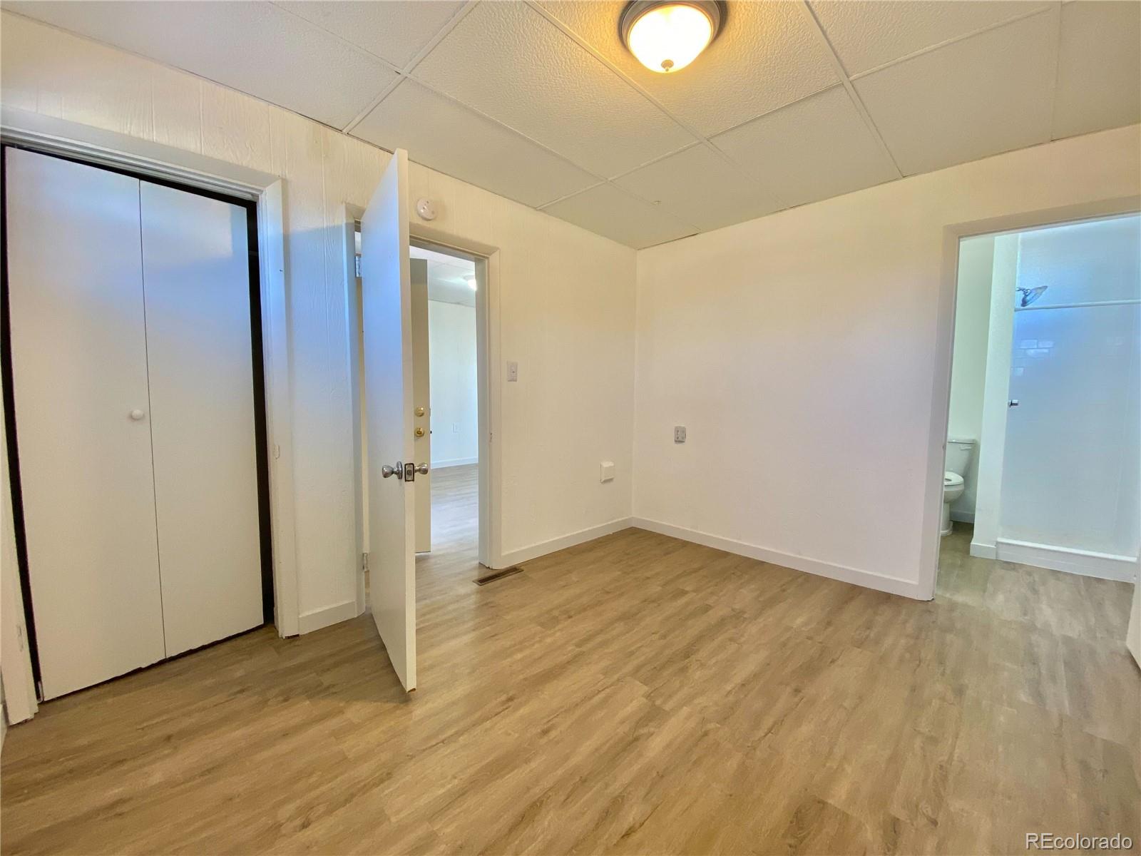 2422 West Vermijo Avenue, Unit 7 Colorado Springs, CO 80904 - Photo 4 of 6 an empty room with wooden floor and windows