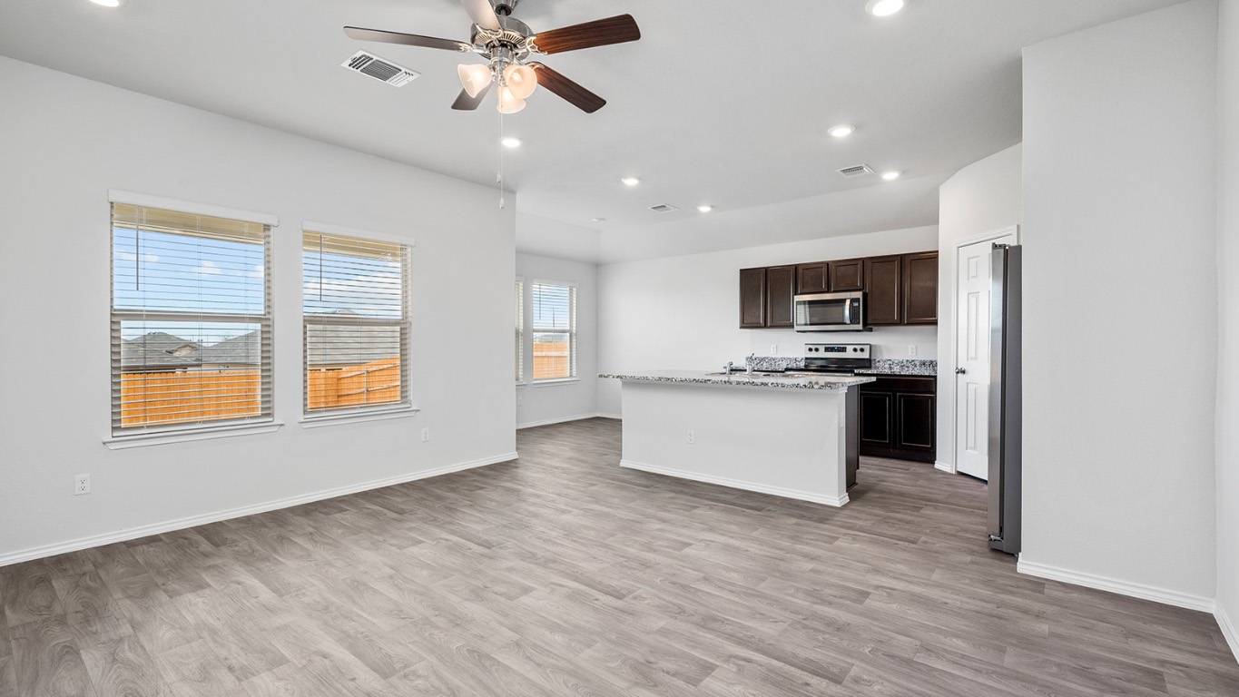 1416 Coriander Road Temple, TX 76501 - Photo 22 of 22 Kitchen with dark brown cabinets, a kitchen island with sink, recessed lighting, light wood-style flooring, and open floor plan