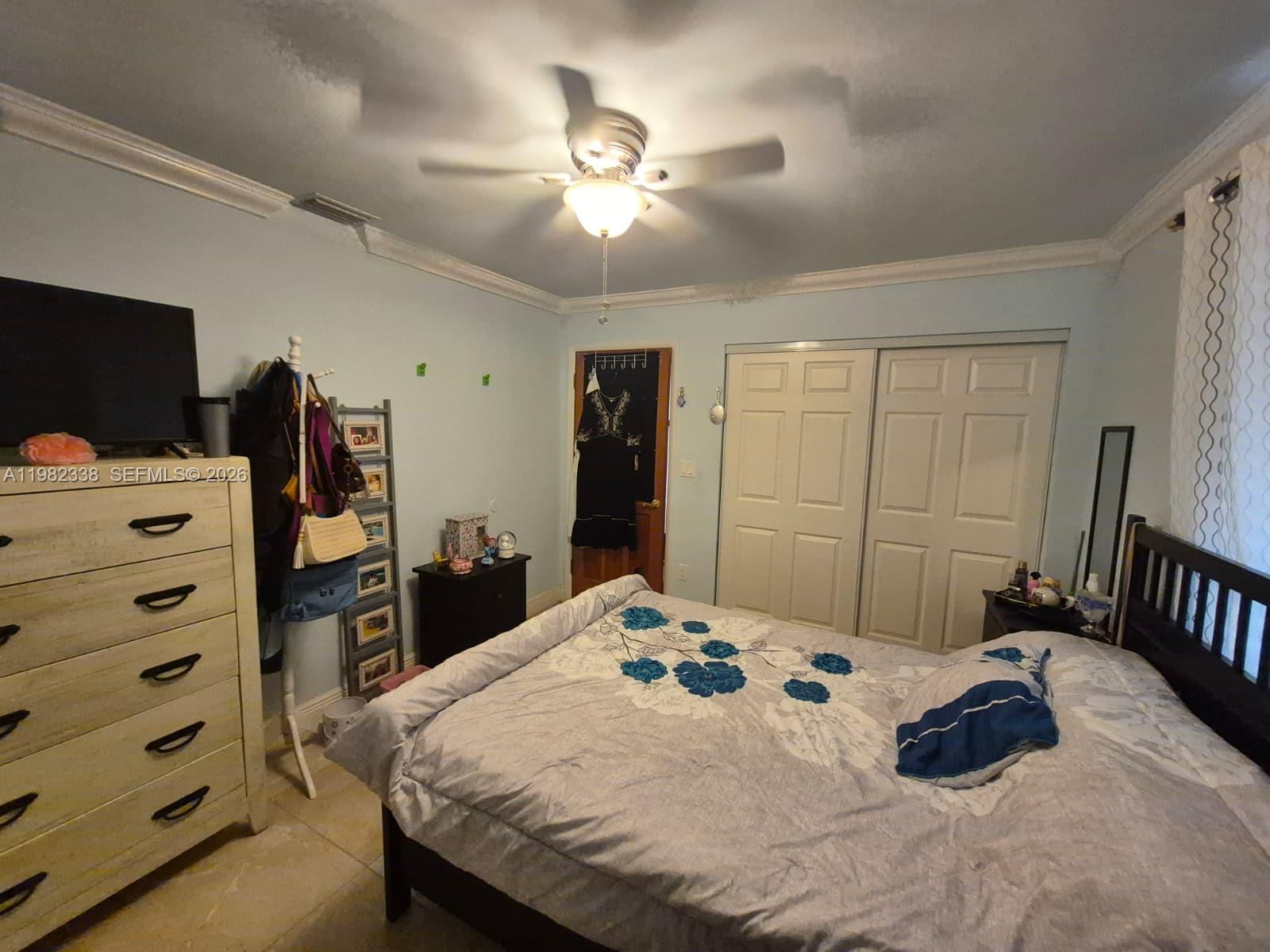 14530 Southwest 110th Street Miami, FL 33186 - Photo 28 of 45 a bedroom with a bed and a chandelier