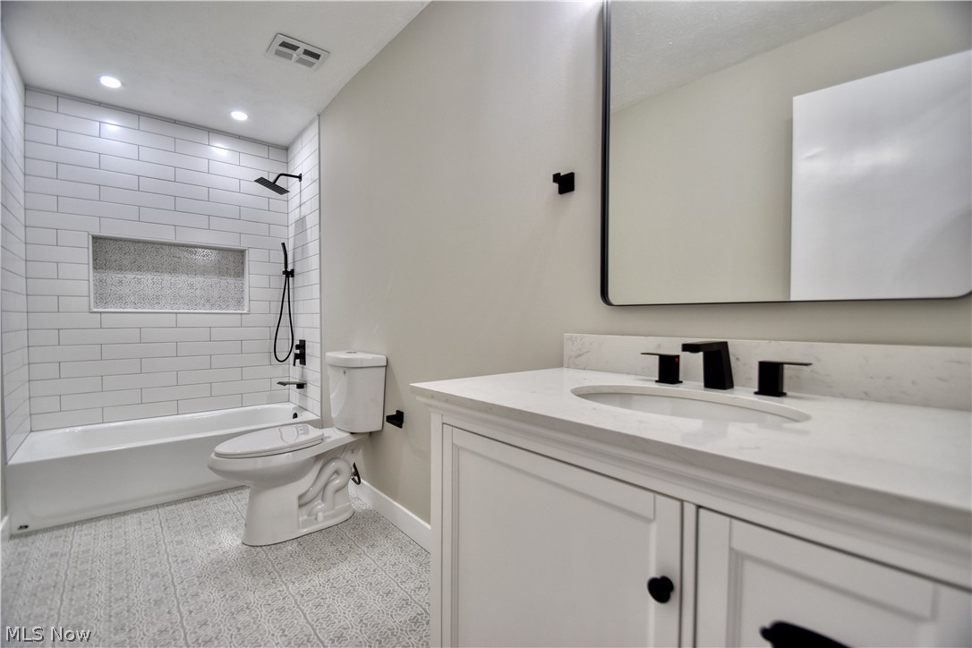 7520 Johnnycake Ridge Road Mentor, OH 44060 - Photo 30 of 36 Full bathroom with vanity, tiled shower / bath combo, tile flooring, and toilet