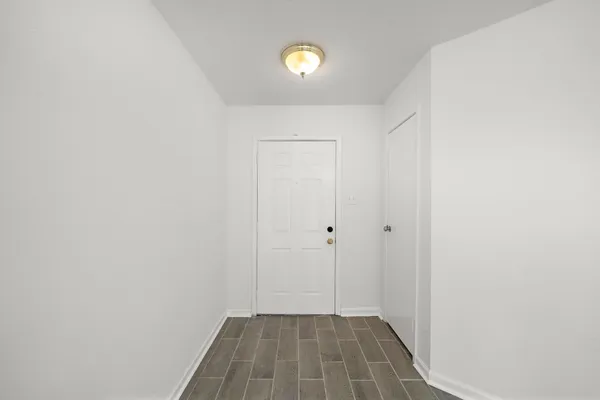 a view of a room with wooden floor and white walls