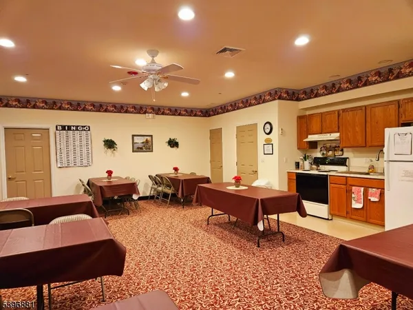 a living room with furniture kitchen view and a wooden floor