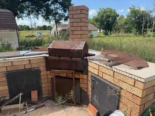 909 Railroad Street Rochester, TX 79544 - Photo 17 of 19 a brick building with a bench in front of it