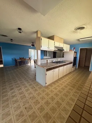 a large bedroom with a bed and a view of kitchen