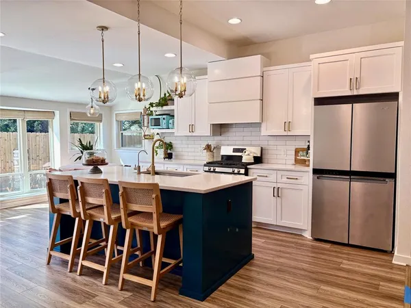 a kitchen with kitchen island granite countertop a sink a center island and stainless steel appliances