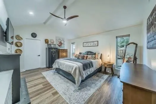 a bedroom with a large bed and a flat tv screen on a dresser