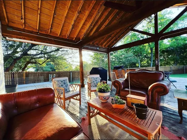 a backyard of a house with table and chairs a fire pit