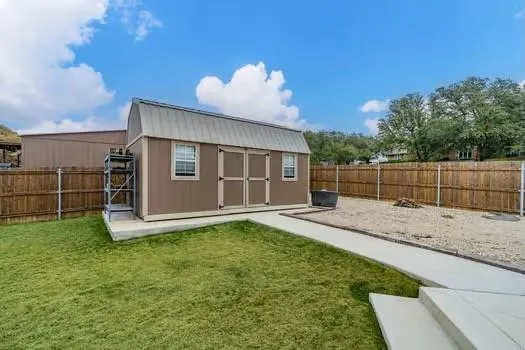 a view of a backyard with floor to ceiling window and wooden fence