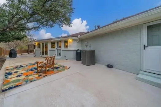 a backyard of a house with barbeque oven table and chairs