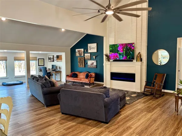 a living room with furniture a fireplace and a chandelier