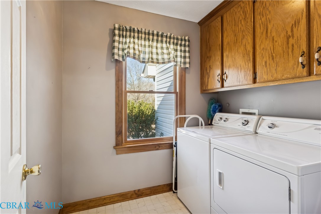 6253 Ark Road Gloucester, VA 23061 - Photo 21 of 38 Laundry room featuring light flooring, washing machine and dryer, and cabinet space