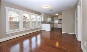 2527 Oakcliff Street Houston, TX 77023 - Photo 2 of 15 a view of empty room with wooden floor and kitchen