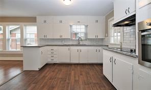 2527 Oakcliff Street Houston, TX 77023 - Photo 5 of 15 a kitchen with granite countertop a sink and cabinets with wooden floor