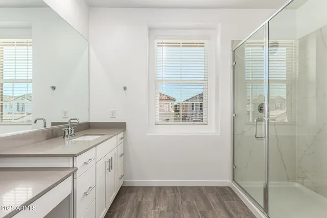 a bathroom with a granite countertop sink a shower and a mirror