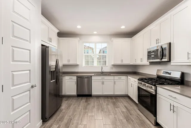 a kitchen with granite countertop stainless steel appliances a refrigerator stove and microwave