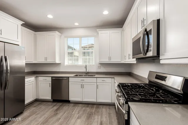 a kitchen with stainless steel appliances granite countertop a stove a sink and a refrigerator