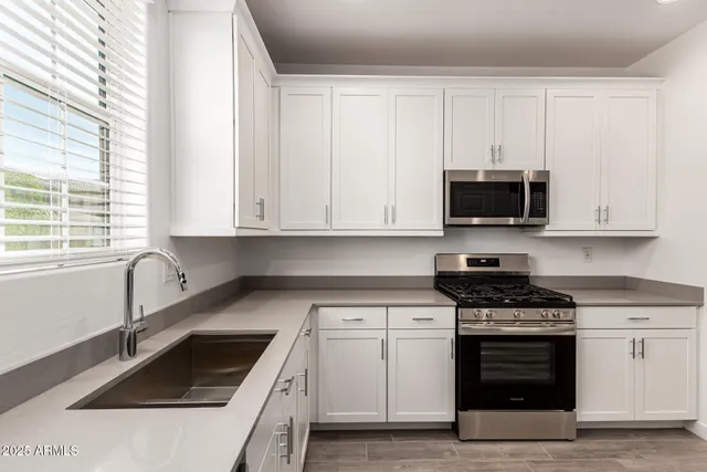 a kitchen with white cabinets and white appliances